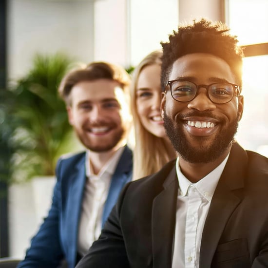 Am looking for happy business people in an office that has a plant in the background warm tones in the image and at least one person in focus These people work in insurance