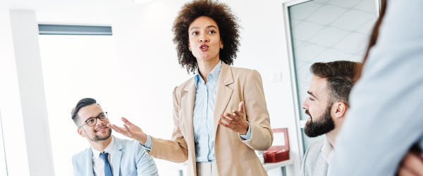 How to Make Your Business Value and Act on CX Data - Woman presenting to colleagues