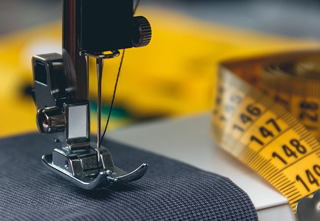 Sewing machine foot and tape measure to illustrate 