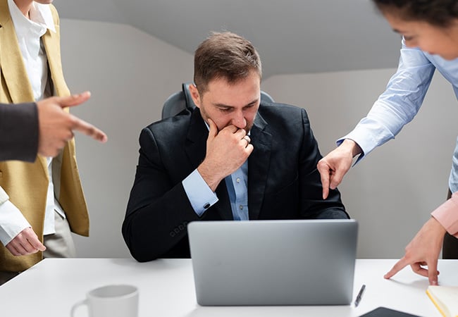 Manager sitting at desk under pressure